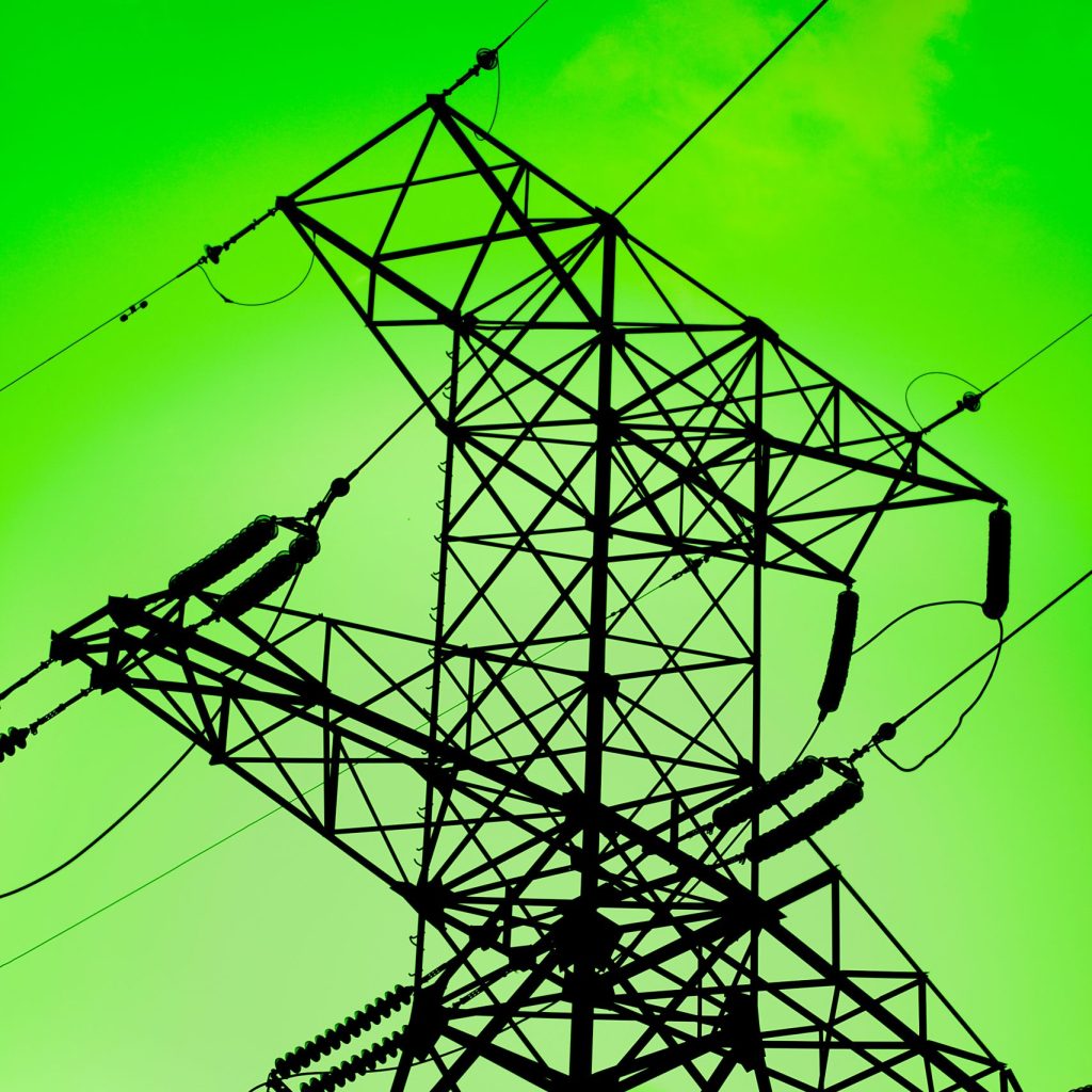 High voltage electricity pylon silouette against green background